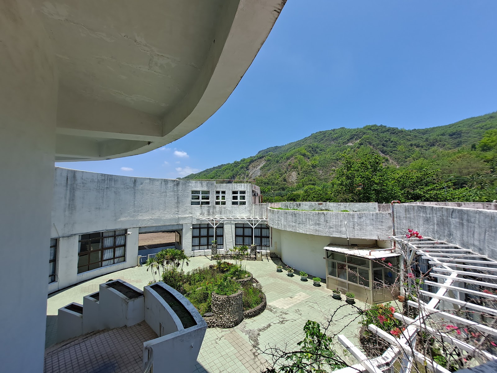 甲仙化石館白色圓形建築側面中庭植栽背景翠綠山頭藍天