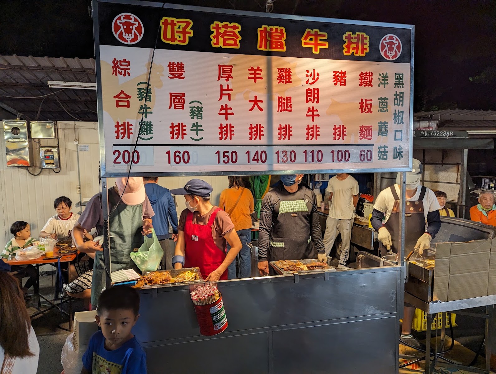 好搭檔牛排攤位招牌與價目表，店員在鐵板前忙碌料理牛排