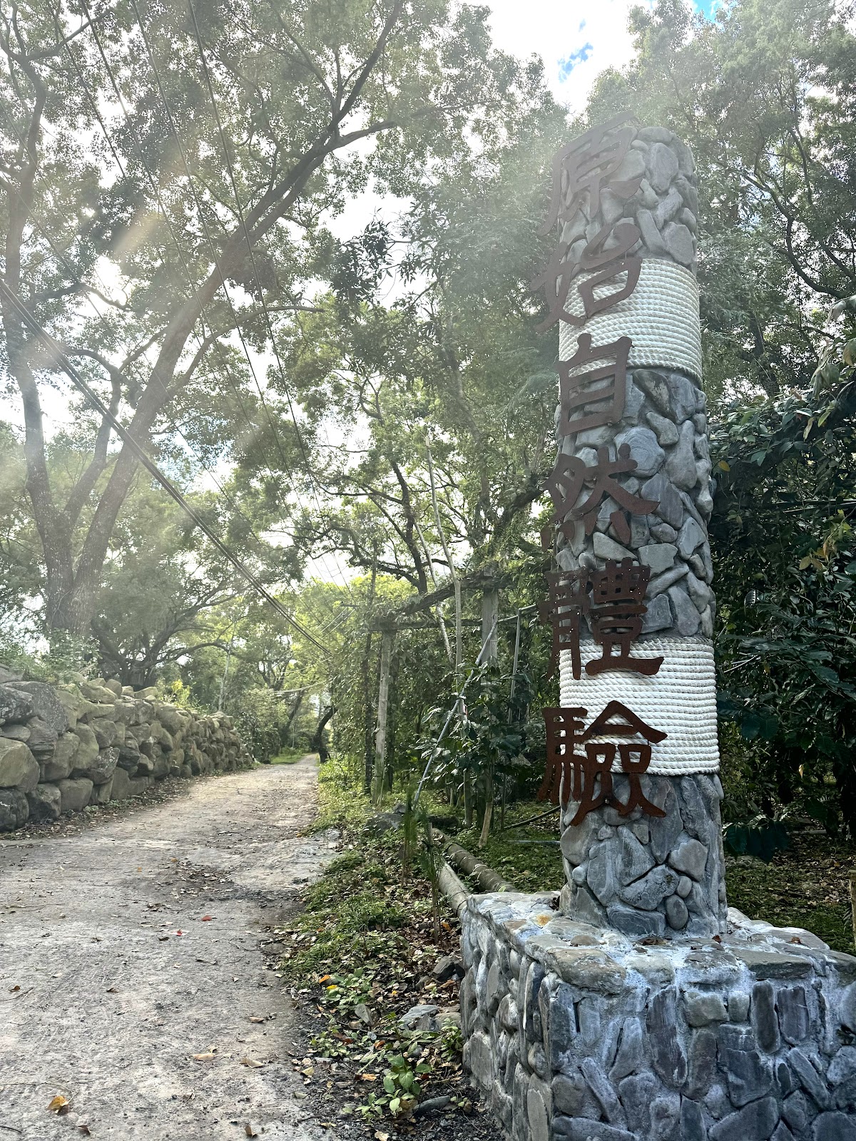 文物館後方歷史尋跡步道入口石碑,周圍綠意環繞的小徑