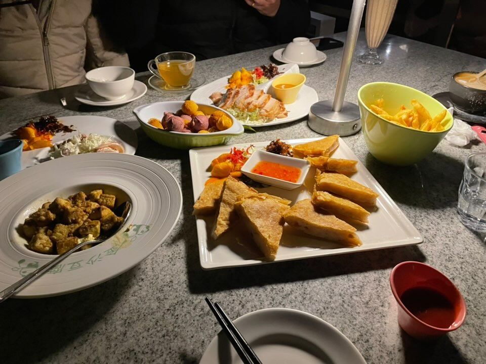 一桌豐盛餐點包含炸物拼盤、薯條、茶飲、甜點與主食