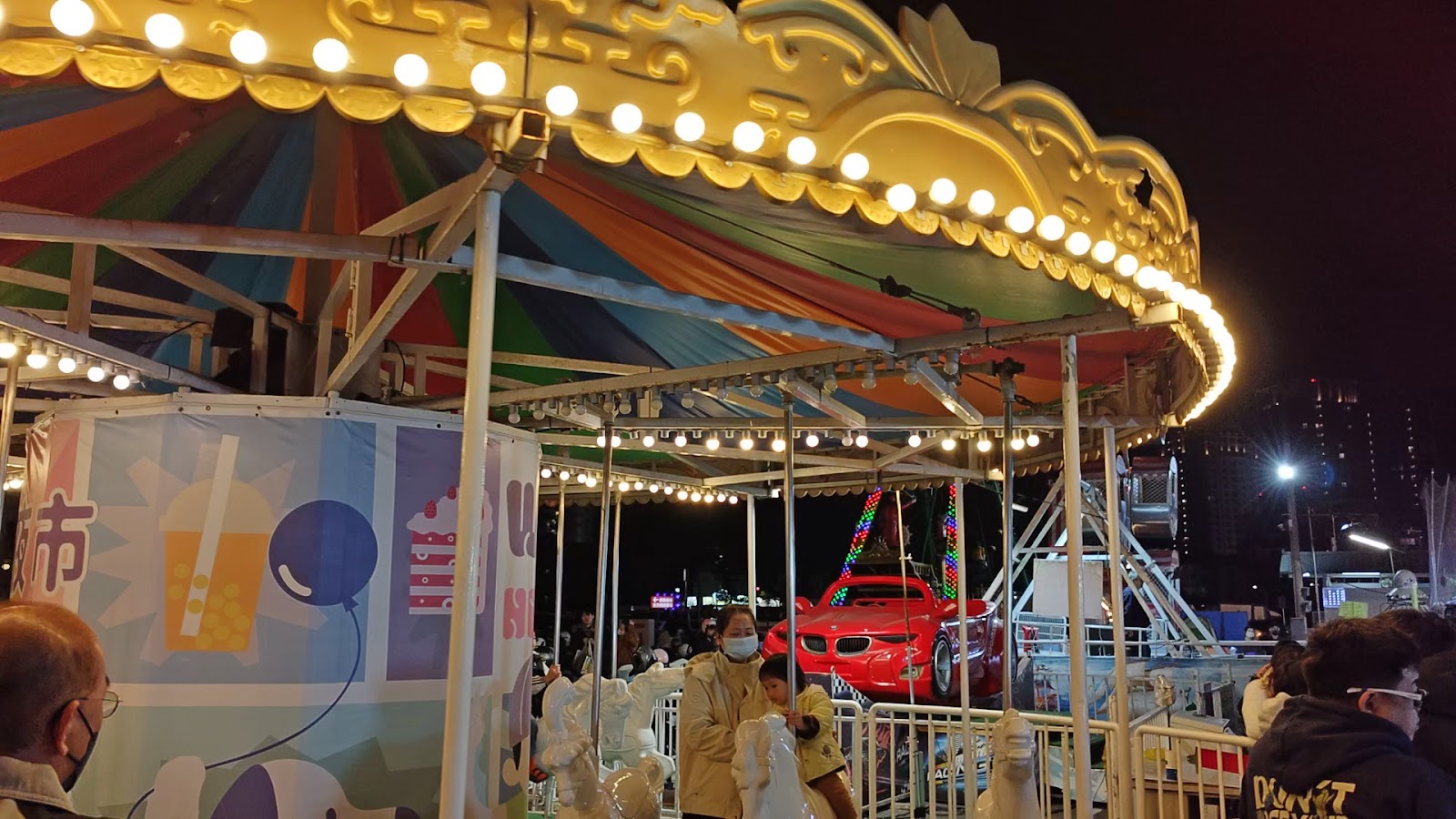 武聖夜市旋轉木馬遊樂設施,夜晚燈光明亮,背景可見摩天輪
