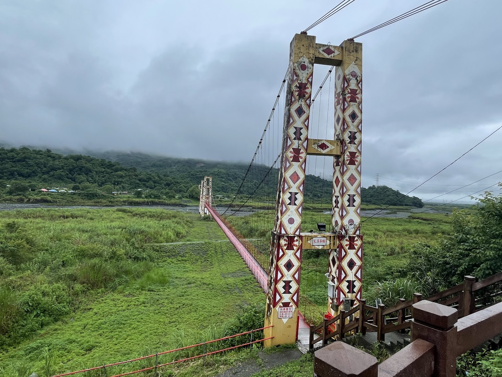 寒溪吊橋近景,橋塔裝飾泰雅族菱形圖騰,背景翠綠山谷