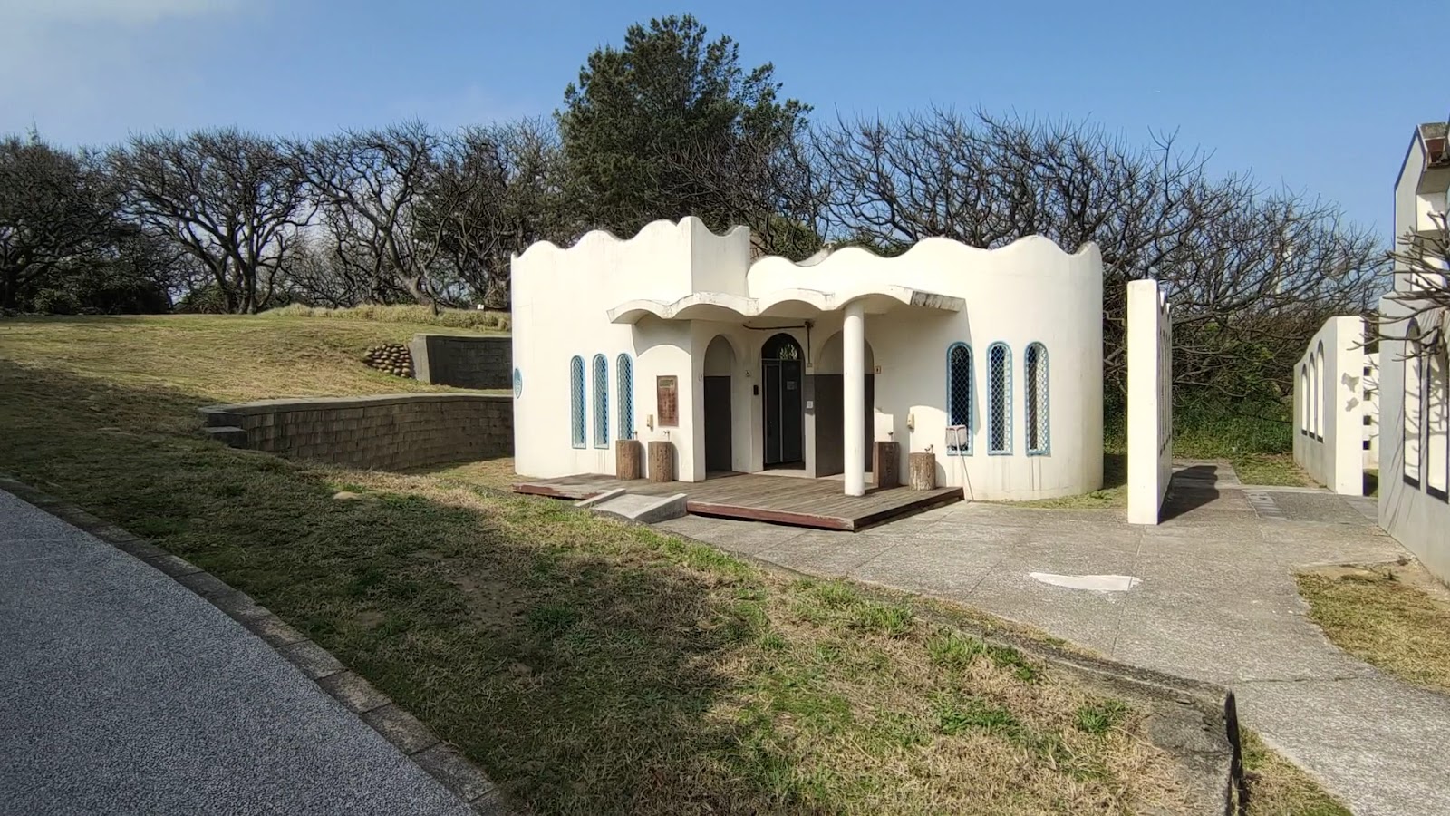 白沙岬燈塔公廁白色波浪屋頂建築外觀,桃園觀音燈塔園區設施