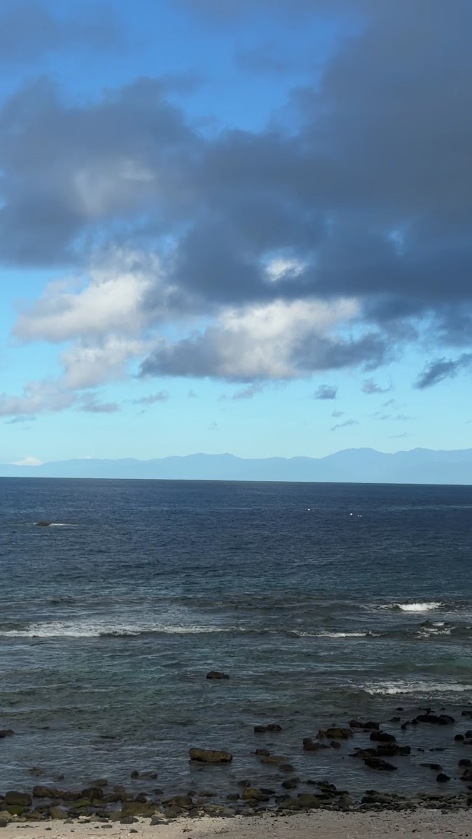 大白沙望向台灣本島海景礁石前景深藍海水遠山綠島