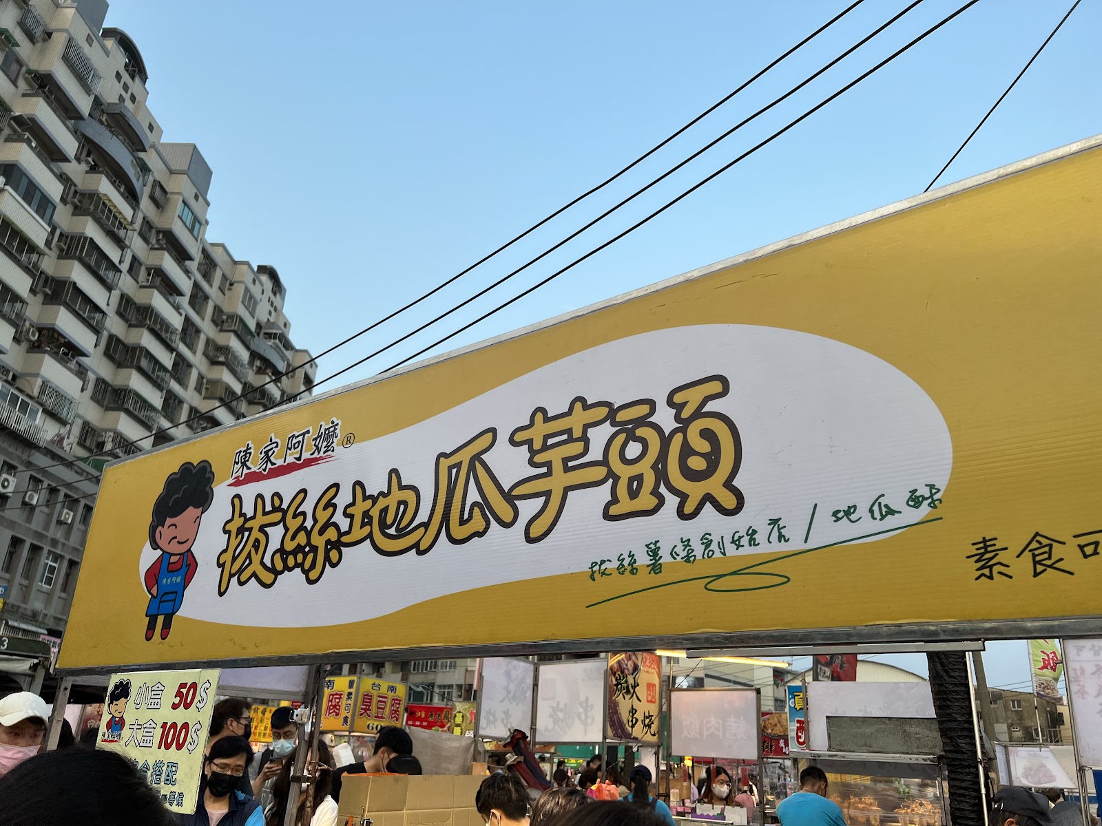 陳家阿嬤拔絲地瓜芋頭招牌,黃底大字,小盒50元大盒100元,素食可食