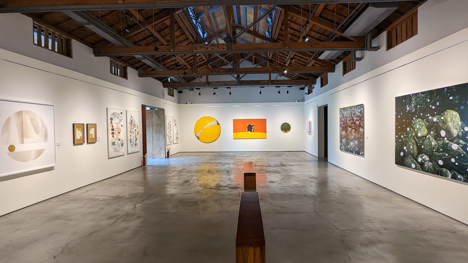 台灣好基金會池上穀倉藝術館室內展覽空間，牆面掛有畫作與長椅