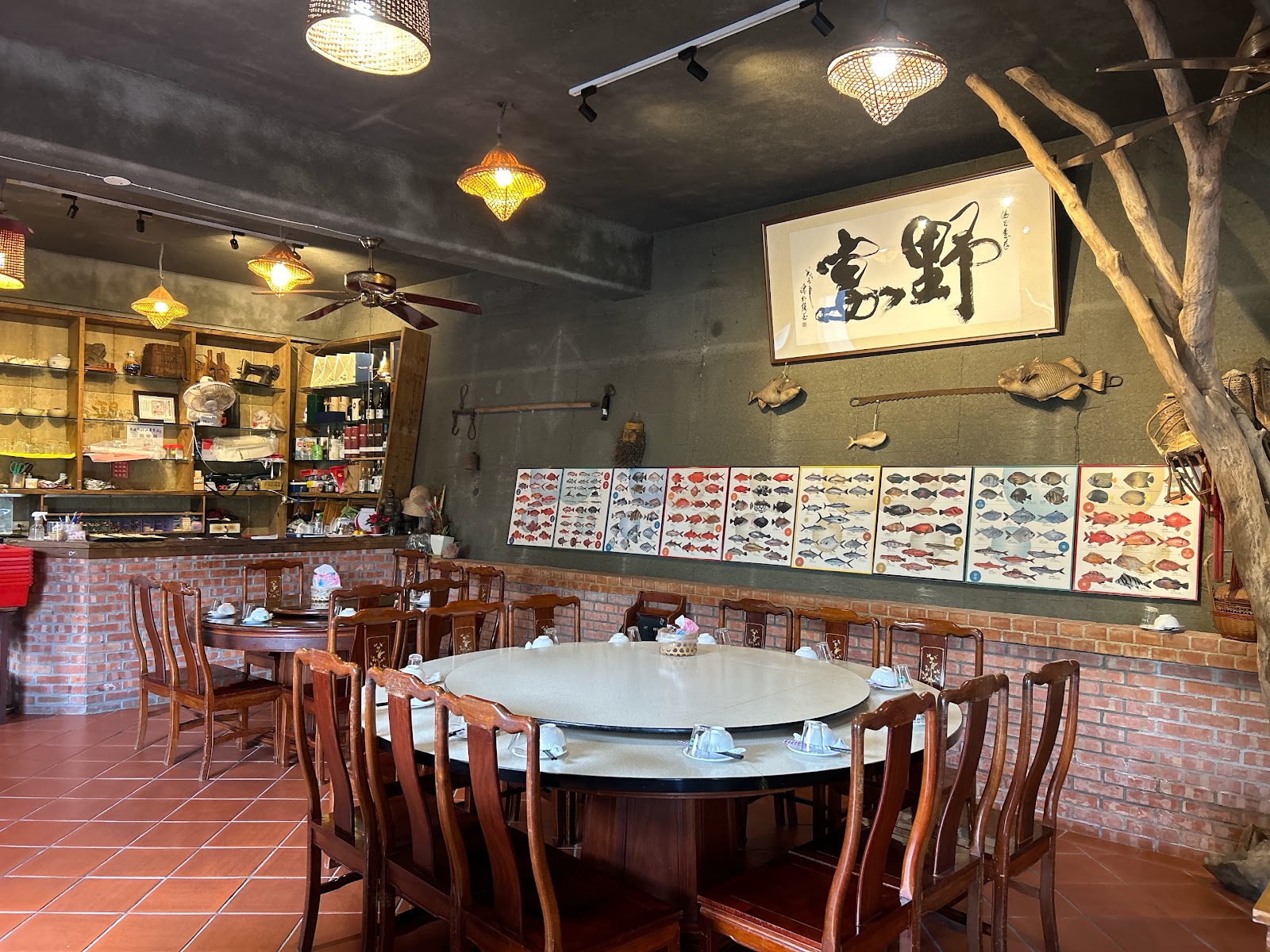 野宴食堂室內用餐空間,牆上掛著「野富」書法字畫與魚類圖鑑