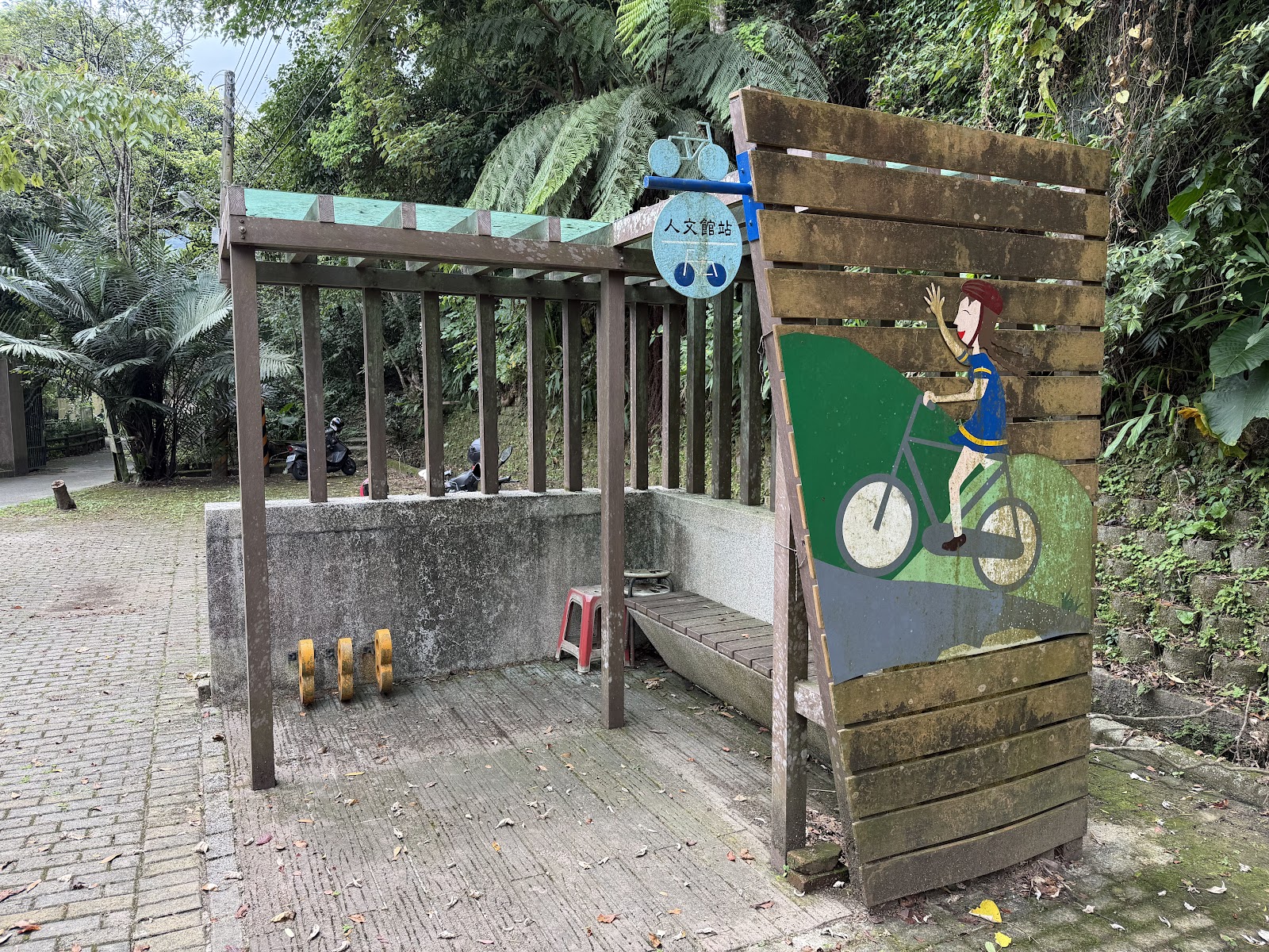 大山背人文生態館旁人文步道休息平台，木造座椅與單車插畫立牌