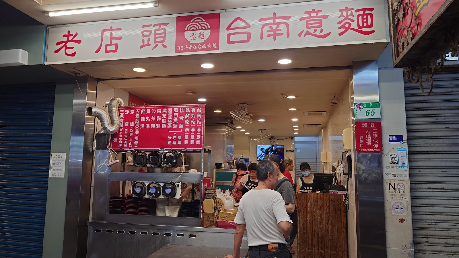 老店頭台南意麵店面招牌，35年老店字樣，店內顧客排隊點餐，門牌通化街65號