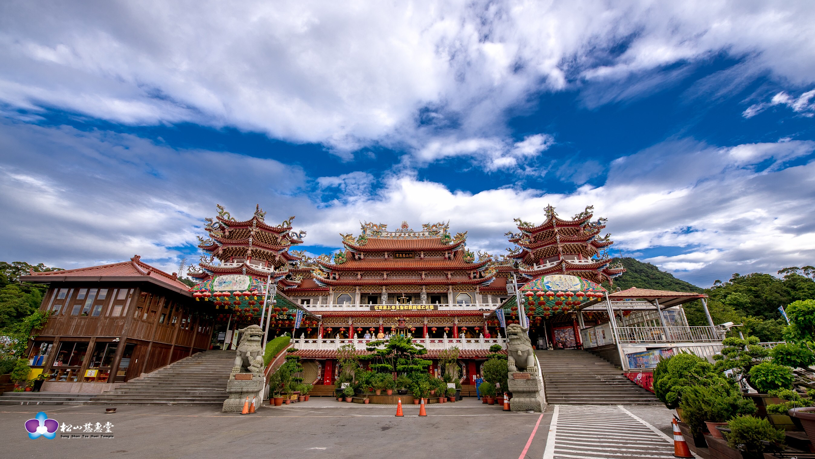 松山慈惠堂紅黃相間廟埕全景與藍天白雲