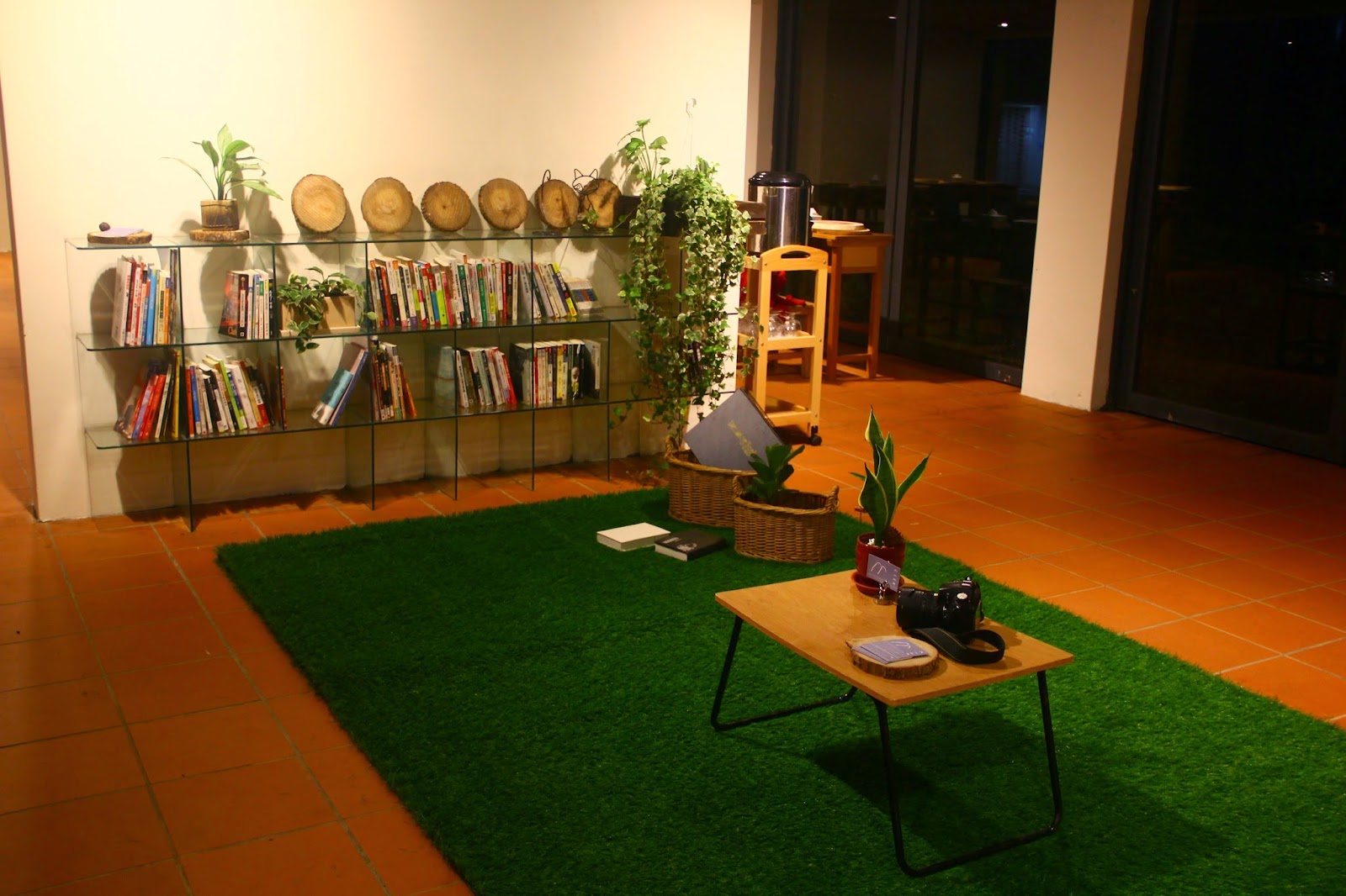 大山背人文生態館室內閱讀休憩區，人工草皮搭配玻璃書櫃，夜晚燈光溫馨