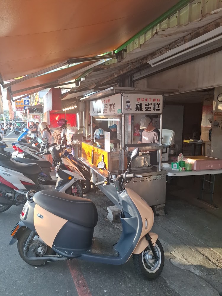 攤位前有機車與排隊人潮，店家現場製作
