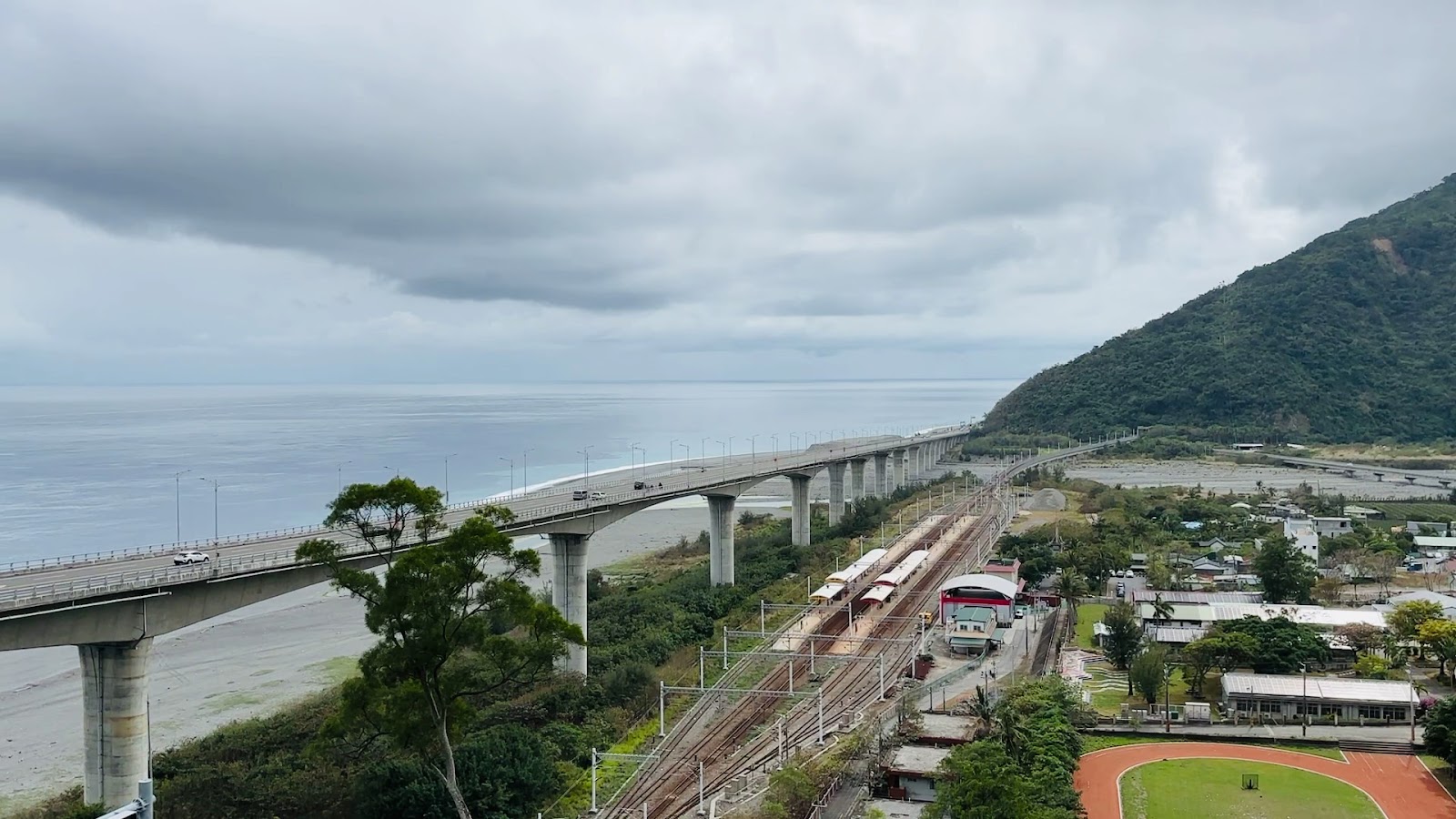金崙觀景臺陰天俯瞰,金崙海岸全景,高架橋、火車站,天空厚重雲層