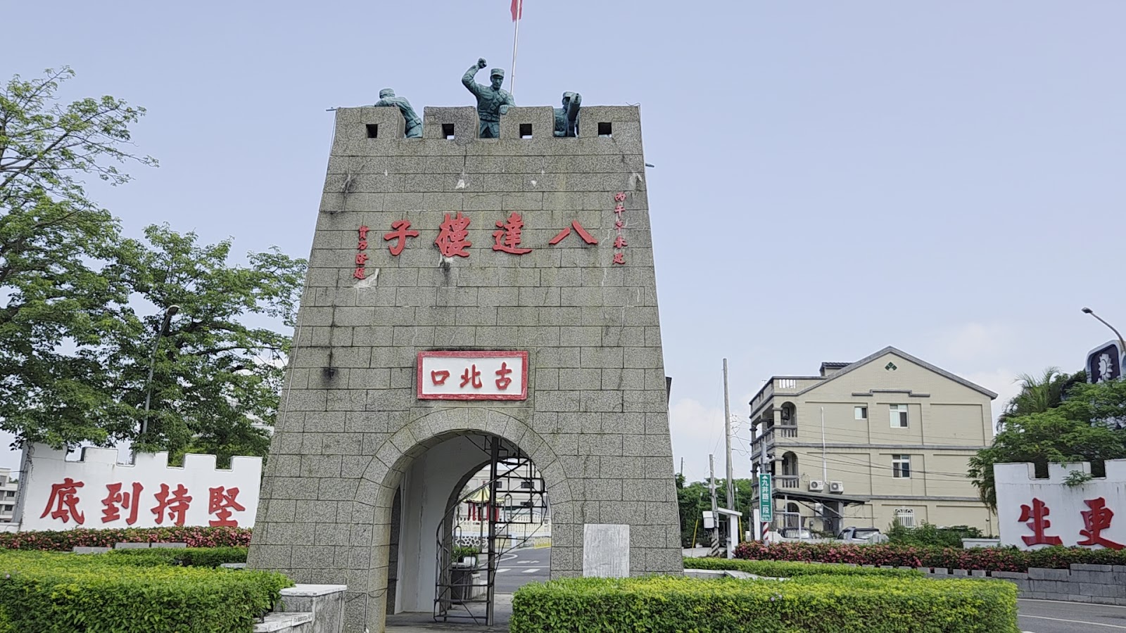 八達樓子方形碉樓正面，樓頂青銅士兵雕像與飄揚的國旗