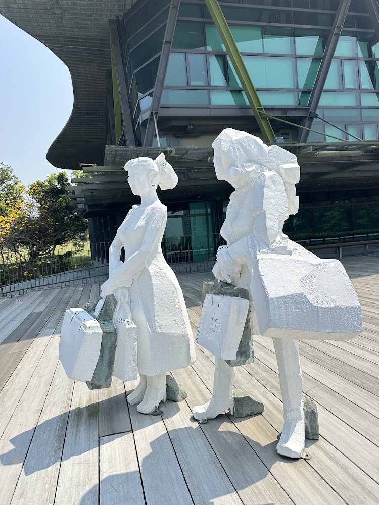兩個白色抽象人物雕塑與現代建築