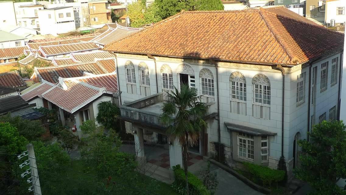 姜阿新洋樓鳥瞰白色兩層建築橙色陶瓦屋頂旁邊傳統三合院