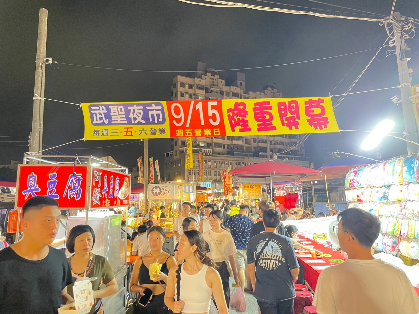 台南武聖夜市入口橫幅,每週三五六營業,人群熙攘