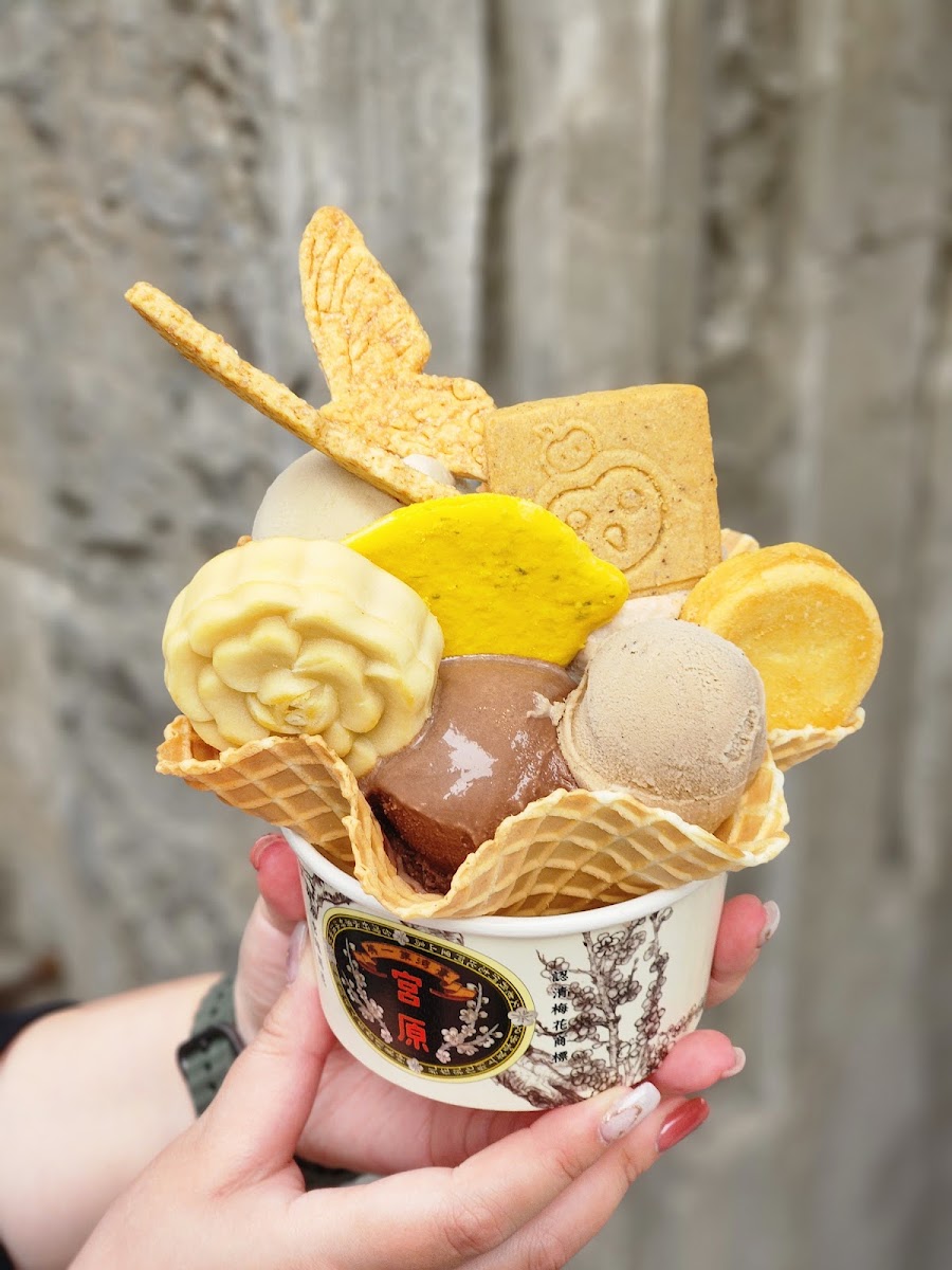 宮原眼科招牌多球冰淇淋,手持宮原品牌杯,多種口味球疊高搭配餅乾裝飾