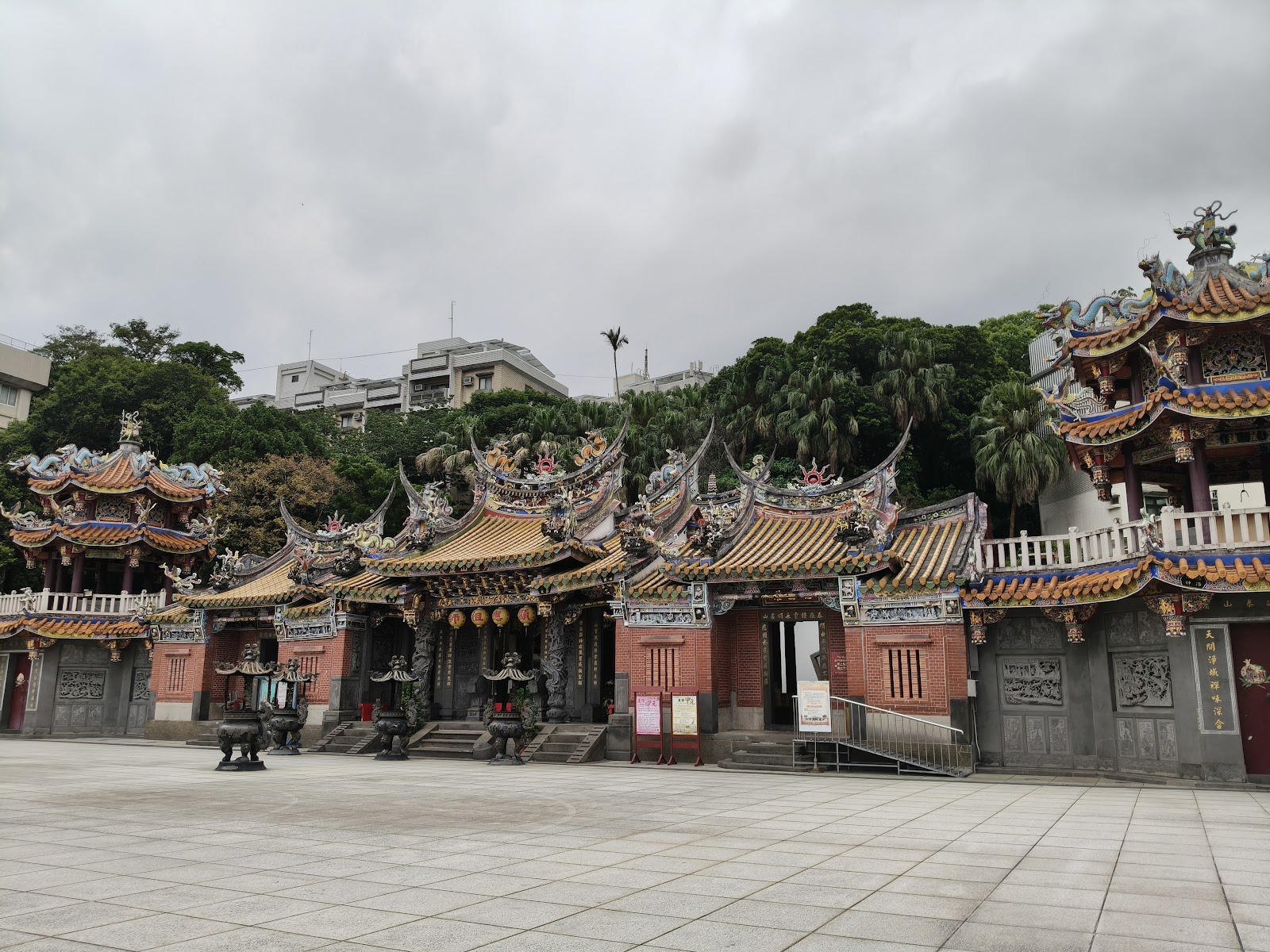頂泰山巖廟宇正面,金黃色琉璃瓦頂有精細龍形雕飾,廣場空曠整潔