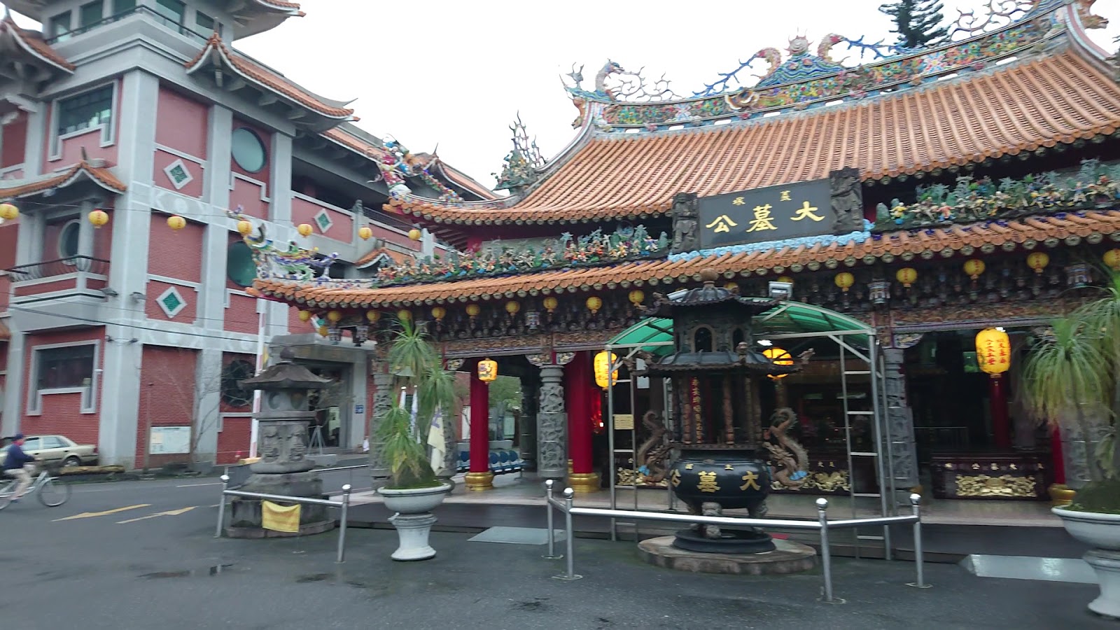 土城義塚大墓公廟埕全景，與對面粉紅色現代大樓形成對比