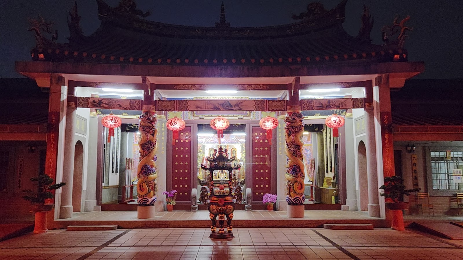 六堆忠義亭夜間內殿，紅色燈籠與神龕