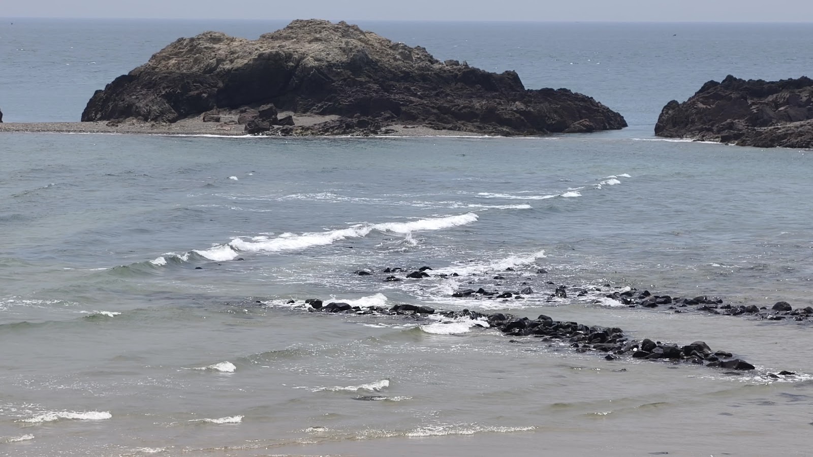 坤坵沙灘周邊海蝕礁石與海浪，海岸線景觀