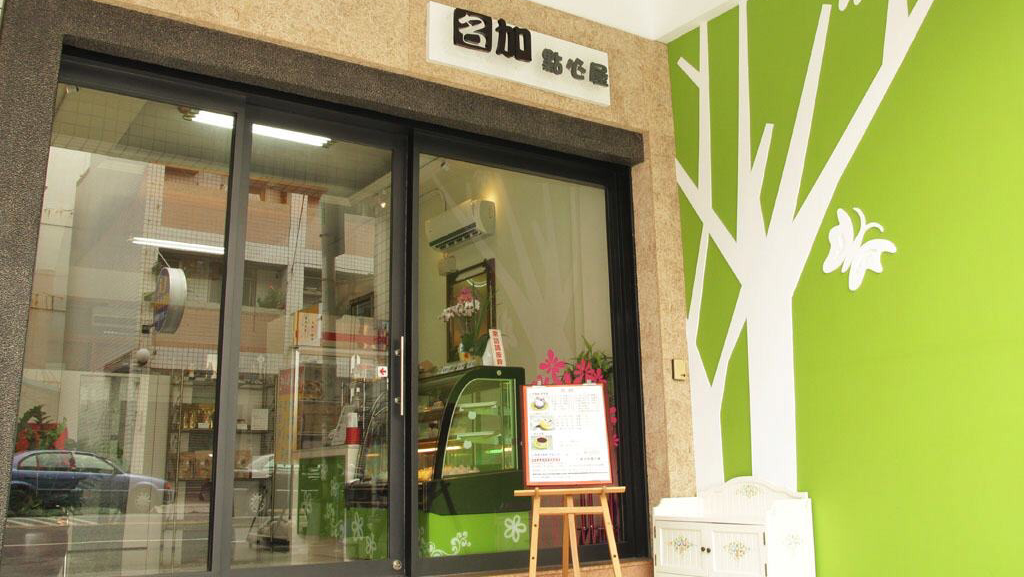 名加點心屋入口與綠色樹木彩繪牆面