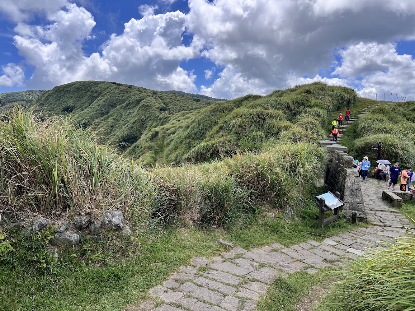 藍天下沿石板步道健行的旅人