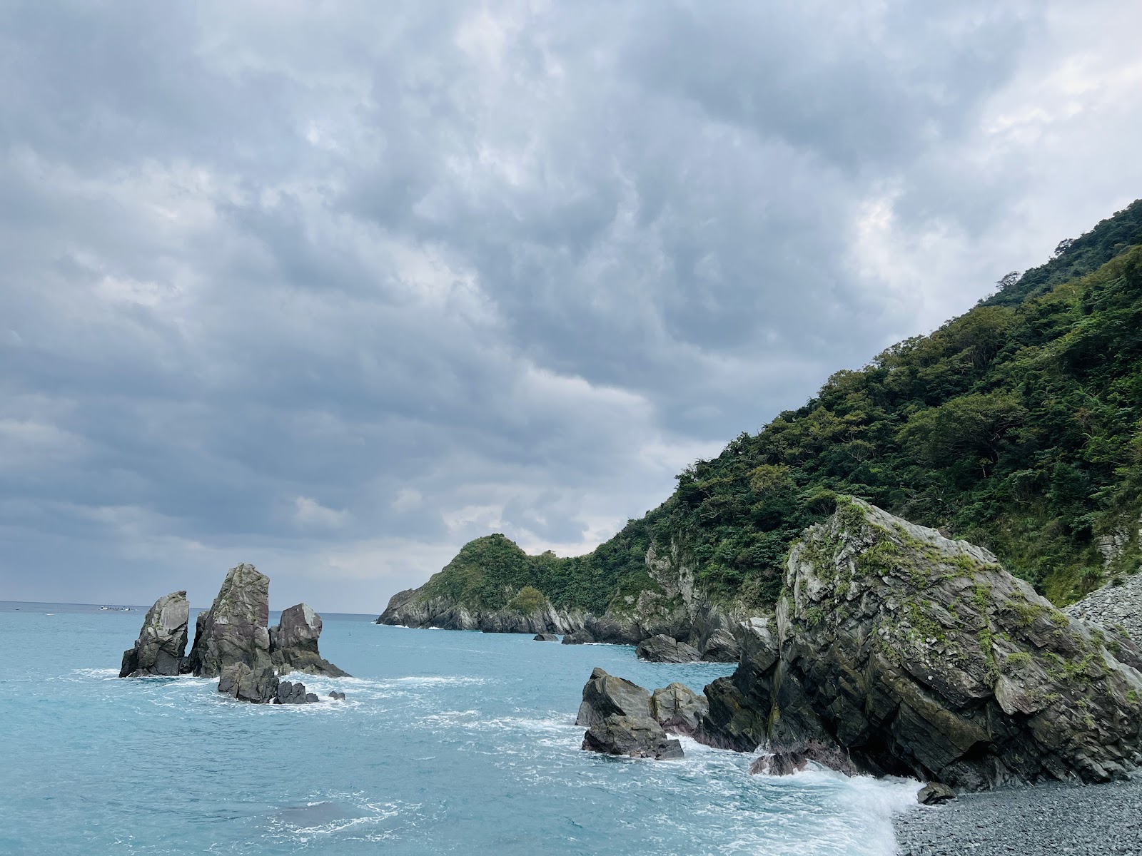 粉鳥林海中修長岩柱群,暗雲壓境,碧綠海水拍打,氣勢磅礴