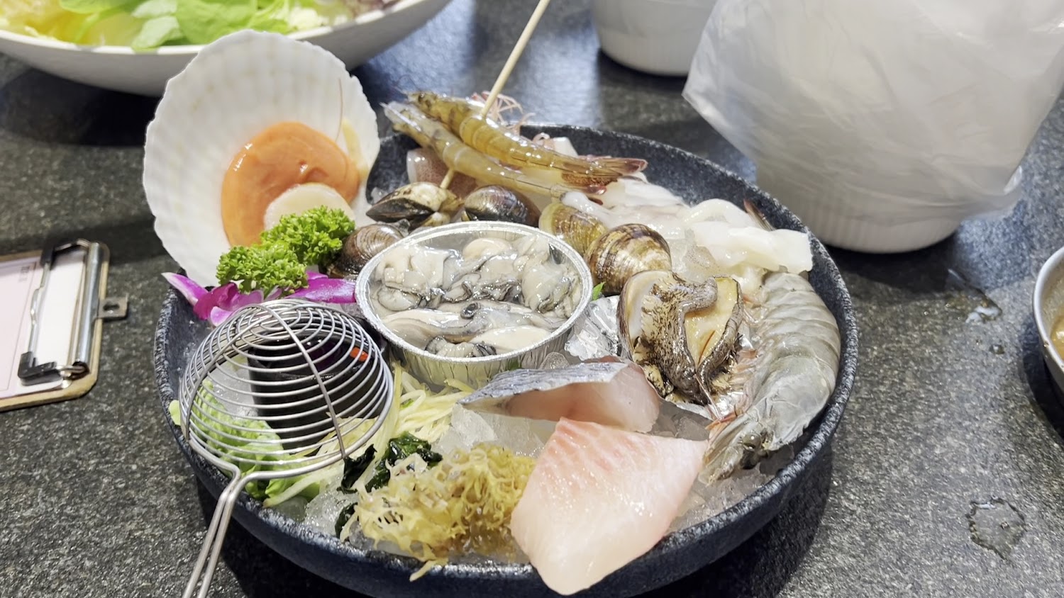 豐富海鮮拼盤包含生蠔干貝魚片蝦子與花枝