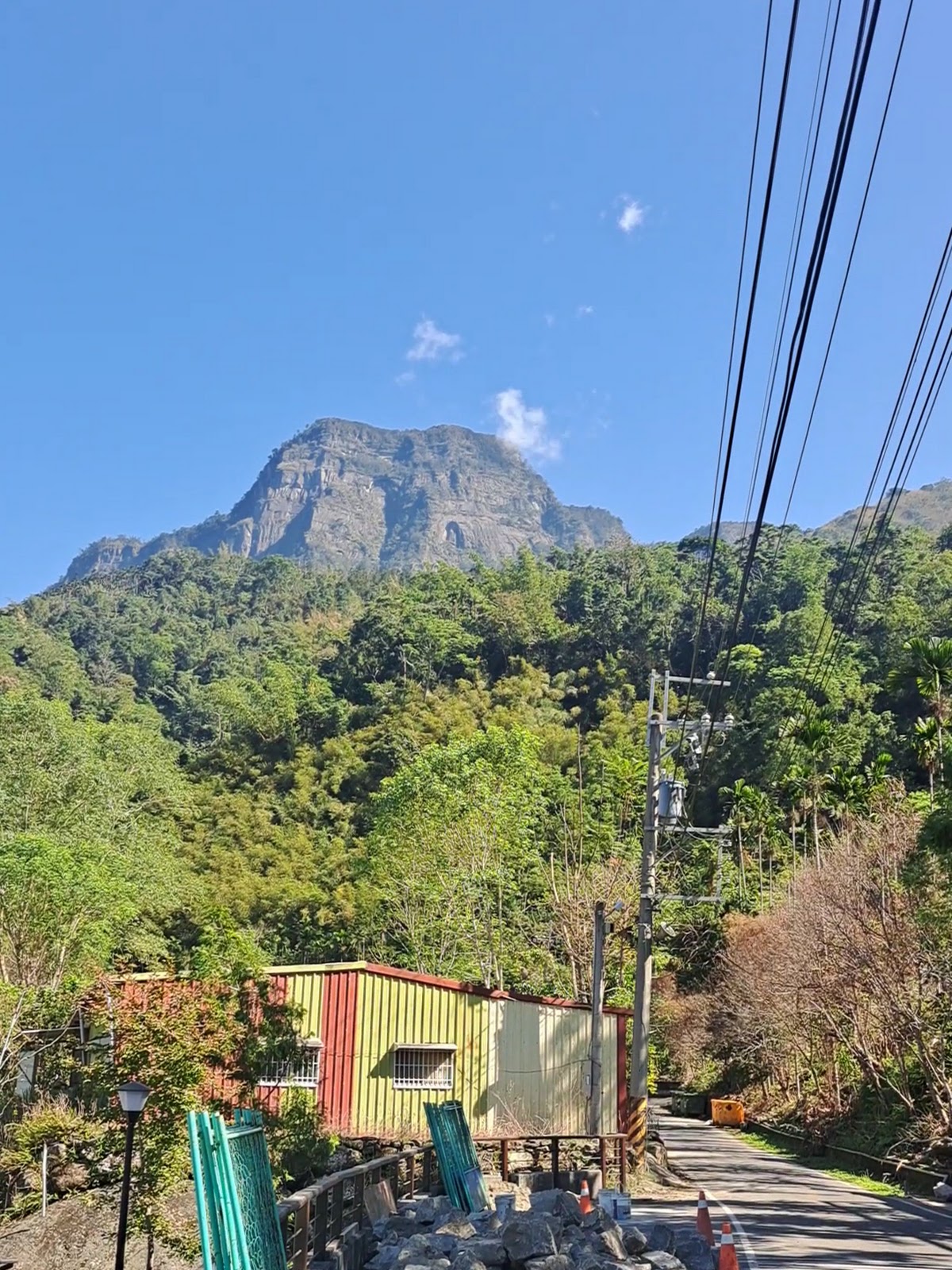 遠眺大塔山山壁與來吉部落屋舍,藍天白雲下的產業道路