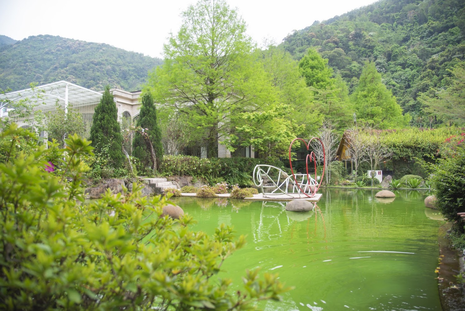 綠意庭園、池塘與愛心裝置的景觀