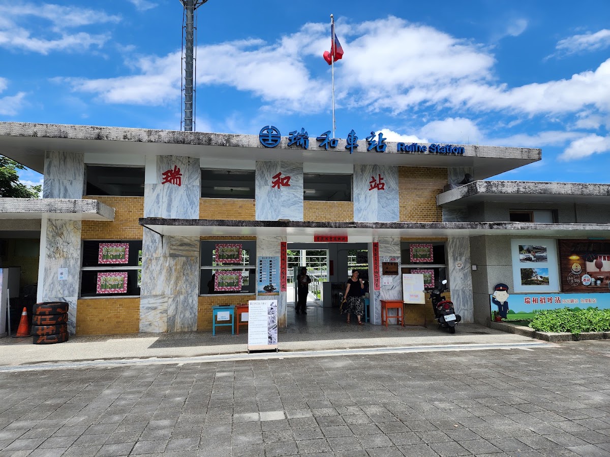 瑞和車站紅磚站房正面,屋頂懸掛國旗,站名招牌寫著Ruiho Station