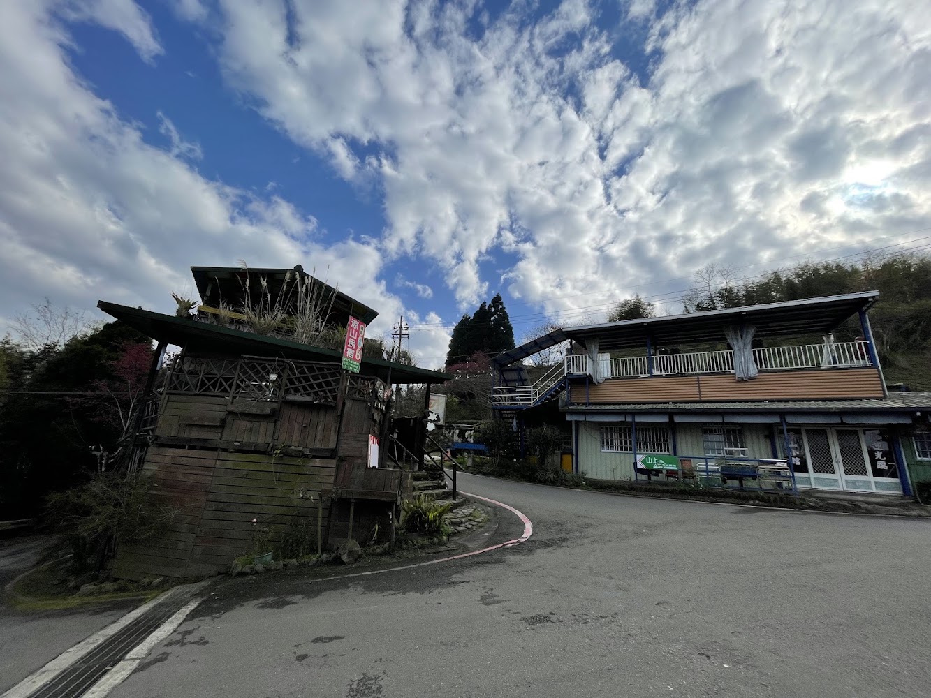 營地周邊兩棟建築與豐富雲層的山區景象