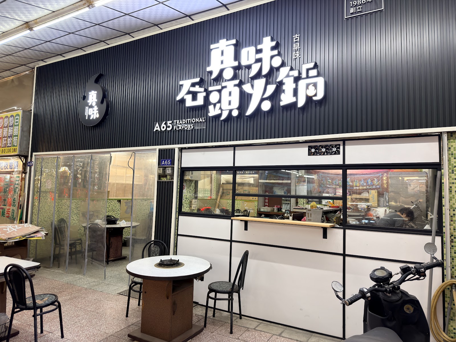 真味石頭火鍋招牌店面，A65攤位號碼標示，1986年創立
