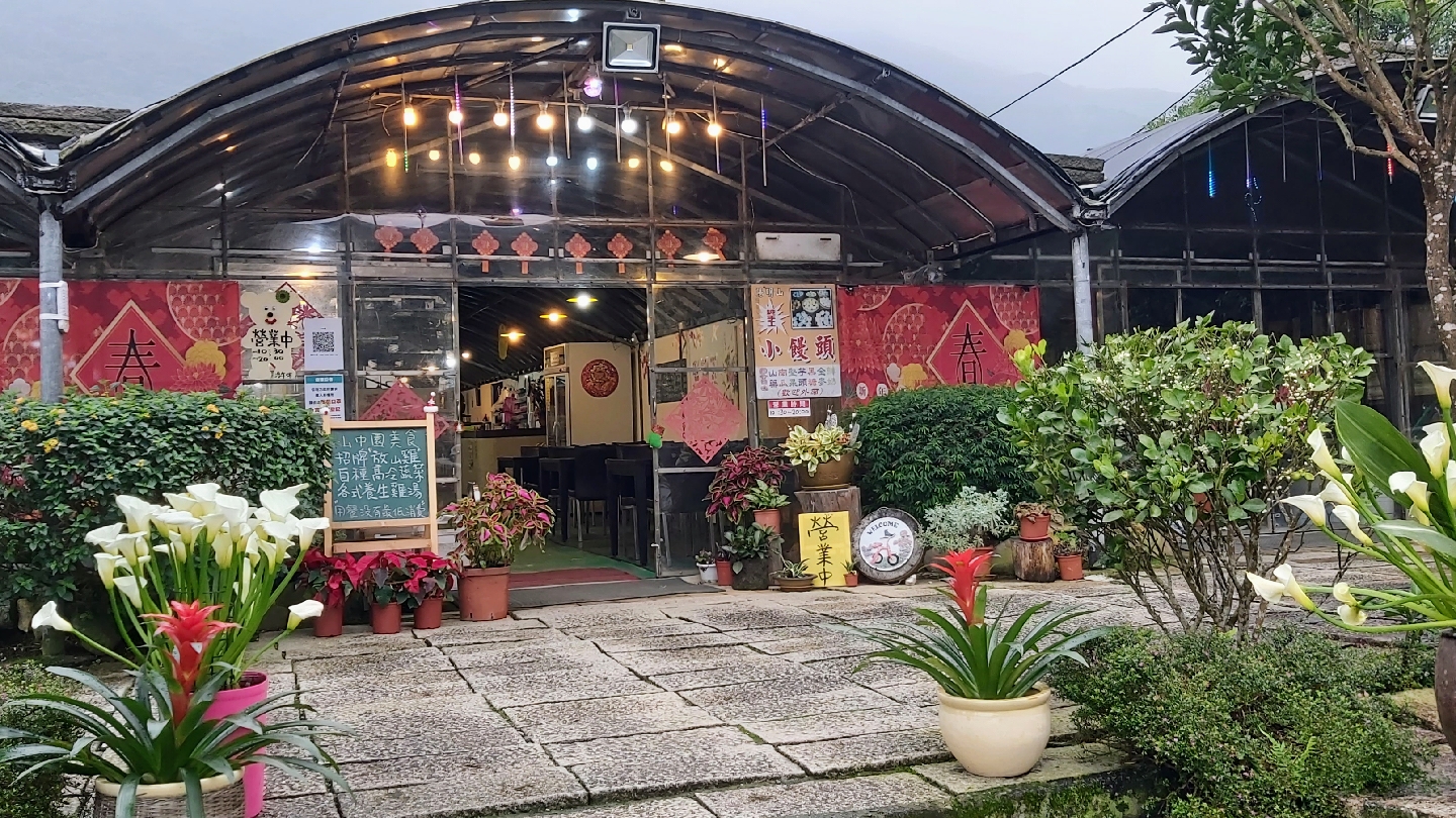 溫室型餐廳入口周圍擺放花卉與盆栽