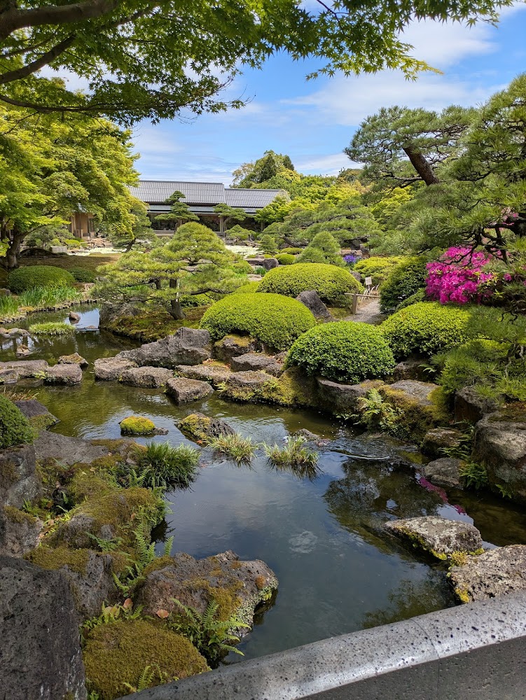 由志園清澈池塘與修剪整齊的綠樹