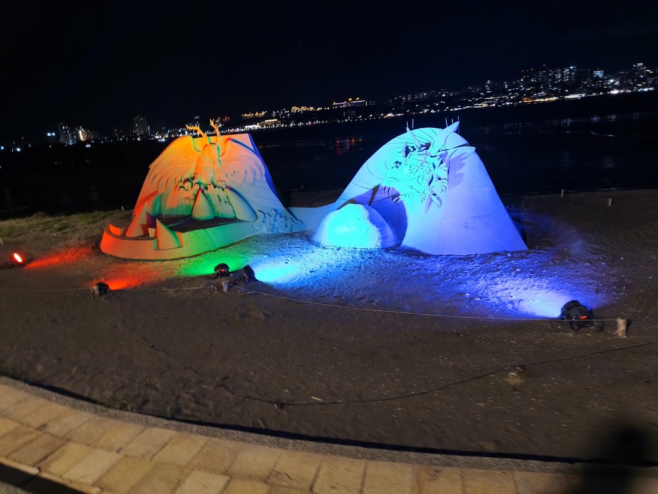 夜間雙沙雕作品與河岸城市燈景