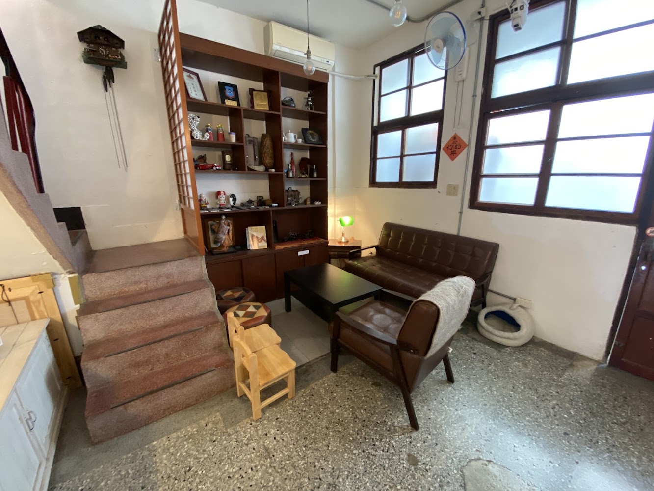 有沙發茶几書櫃與磨石子地板的復古客廳空間