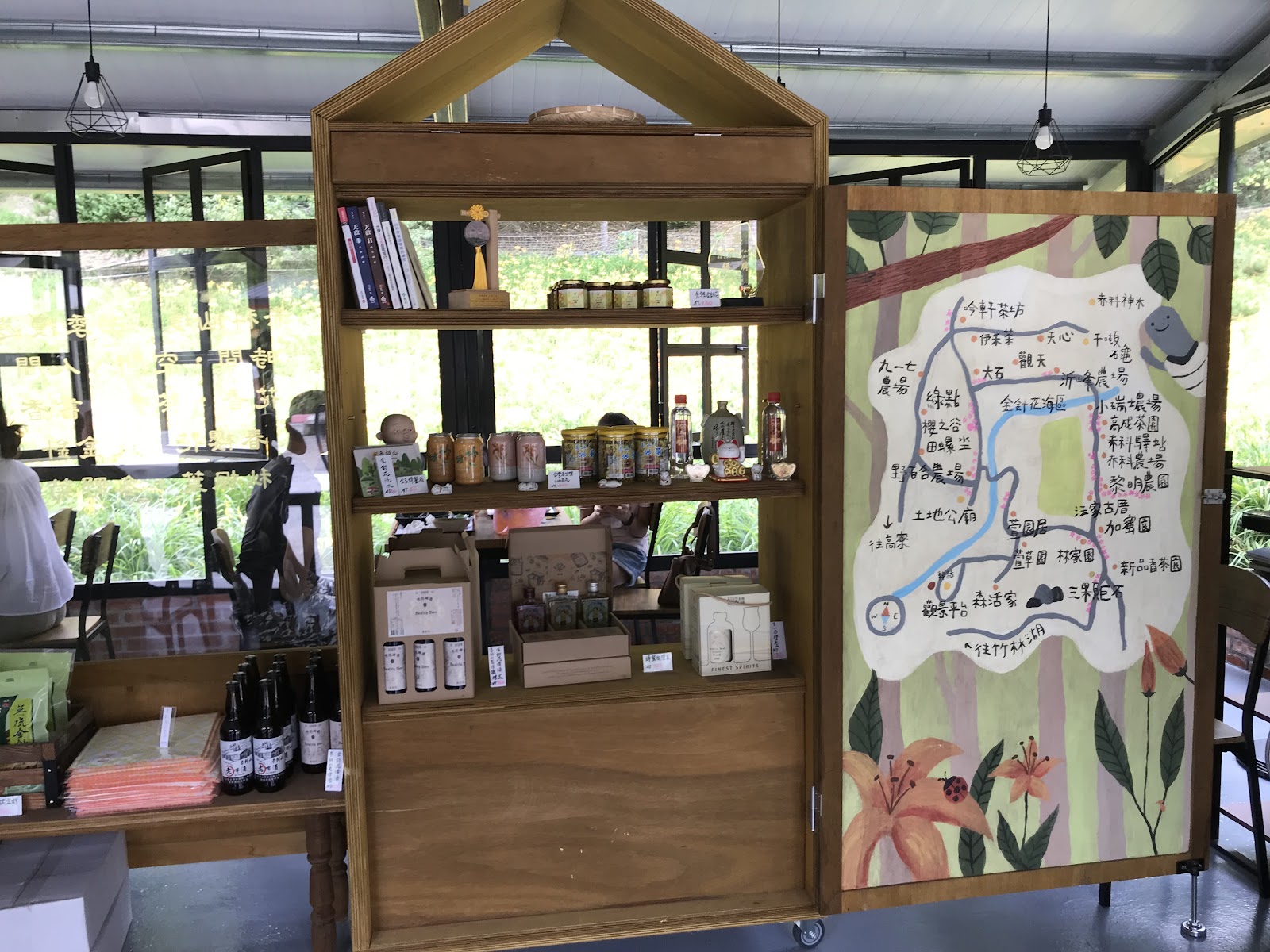赤科山農場商店陳列金針製品伴手禮,牆上有手繪赤科山景點導覽地圖