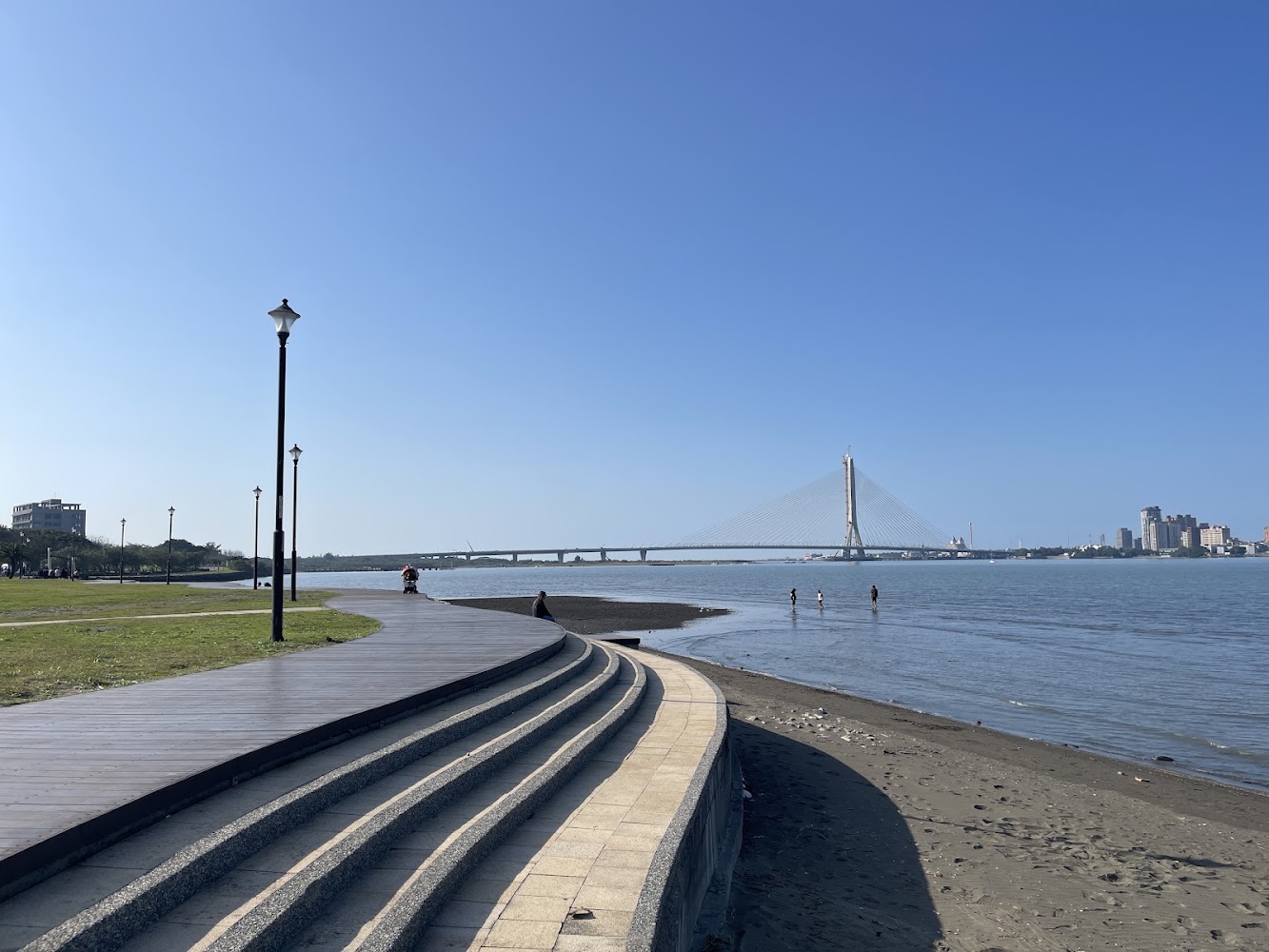 八里左岸公園河畔步道與遠方斜張橋景色