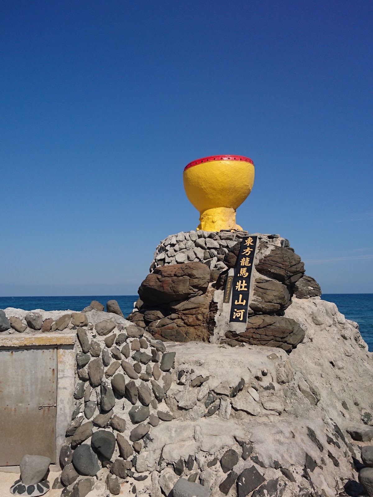 漁村居民用玄武岩碎塊堆疊的小石塔，頂端插著黃色浮球