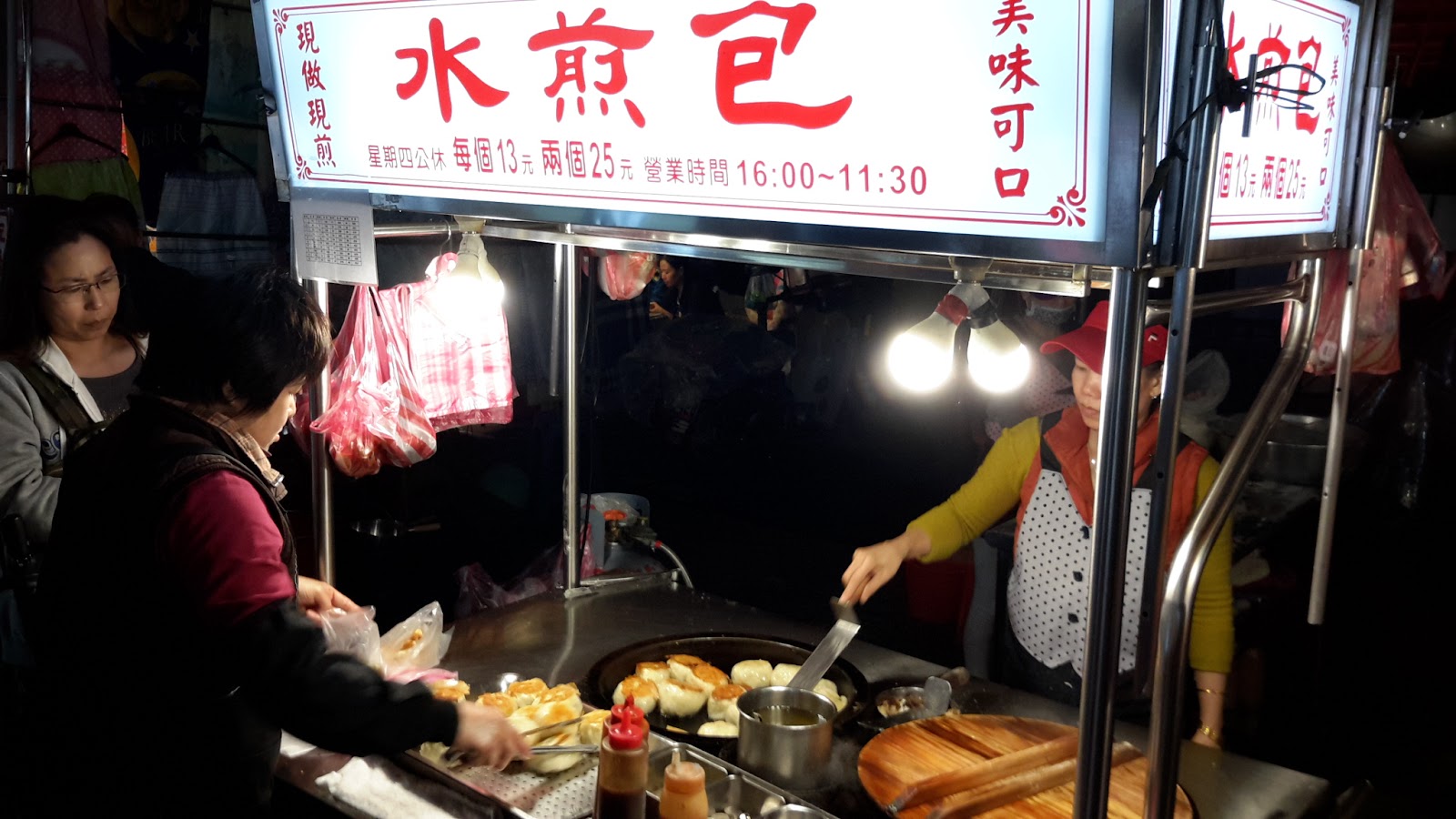 基隆廟口夜市水煎包攤位，老闆現做現煎，顧客在旁等待