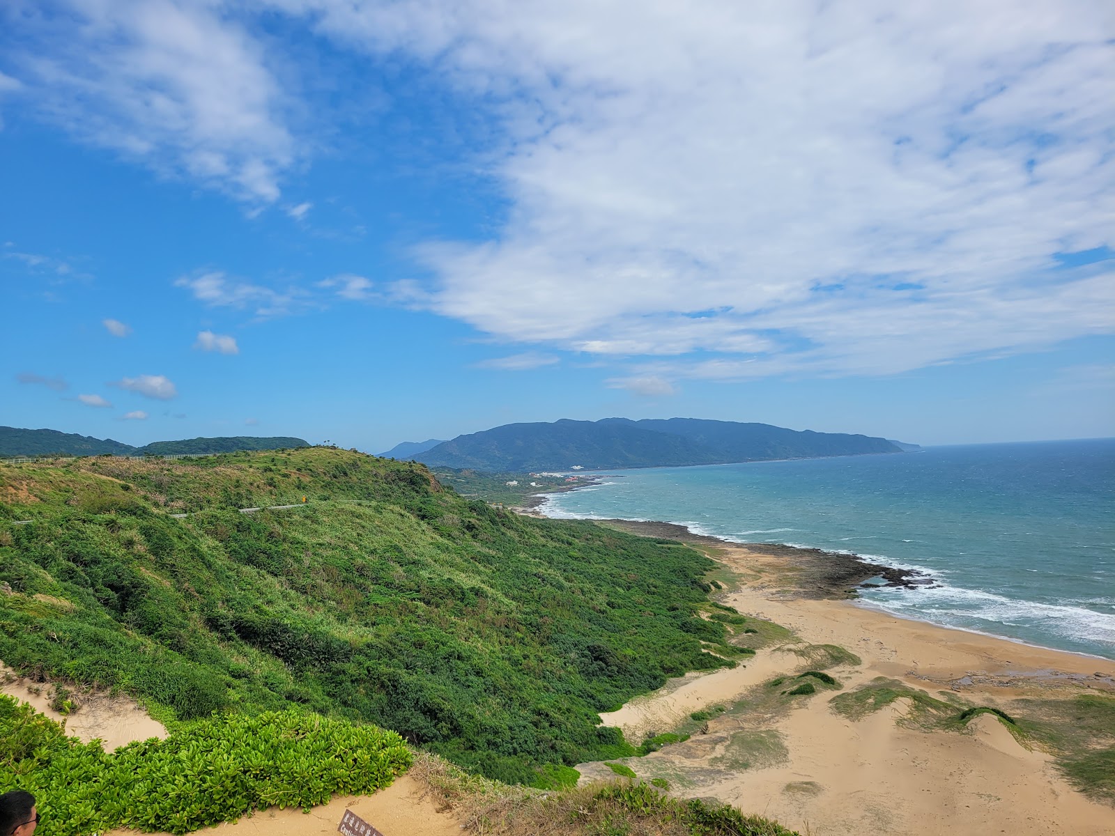 風吹砂高地俯瞰全景,翠綠山丘、金色沙丘、碧藍太平洋和遠山連成一線