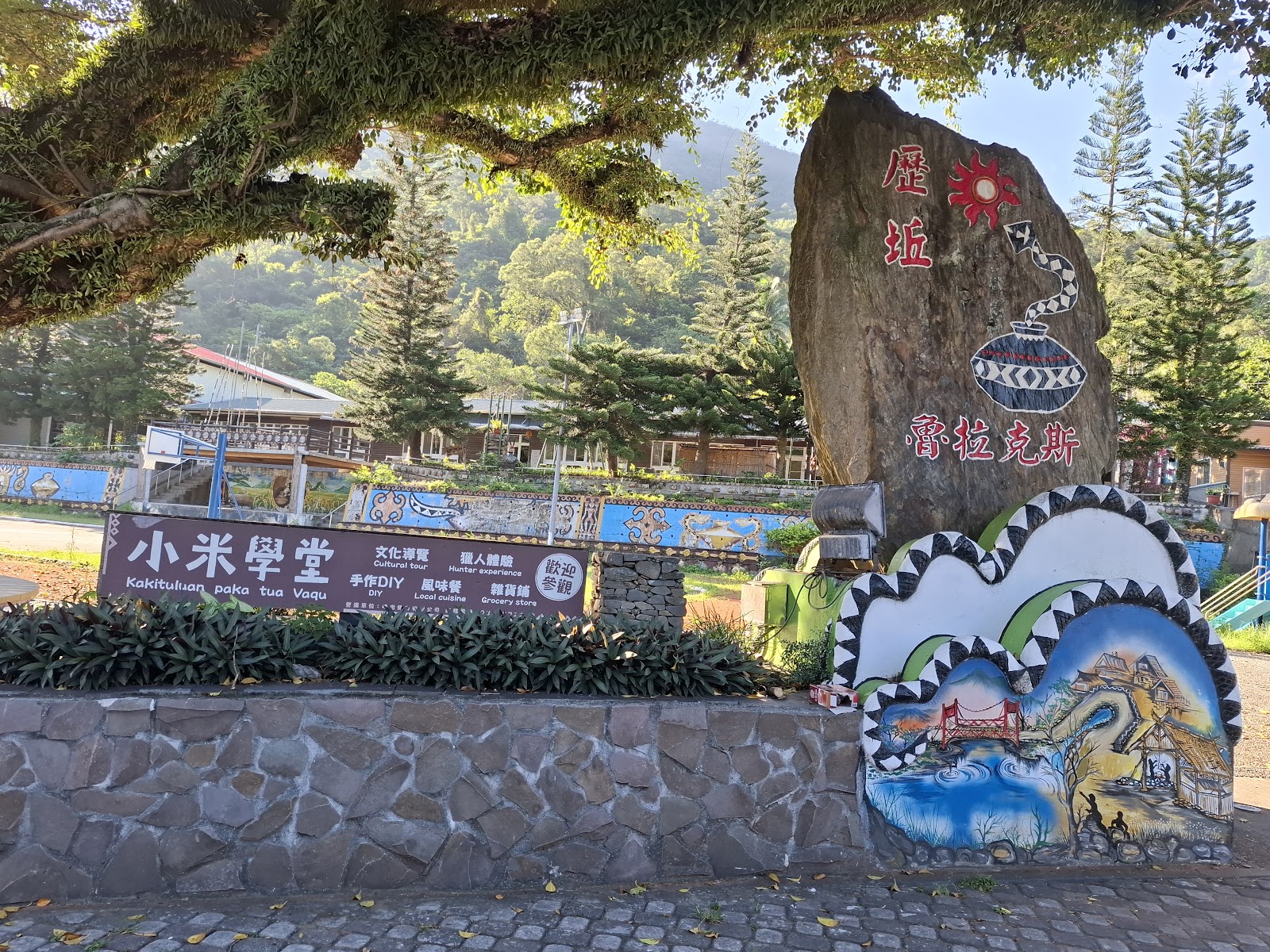 台東金峰鄉小米學堂廣角,石碑指示牌、排松柏、彩繪圍牆,晴天早晨光線