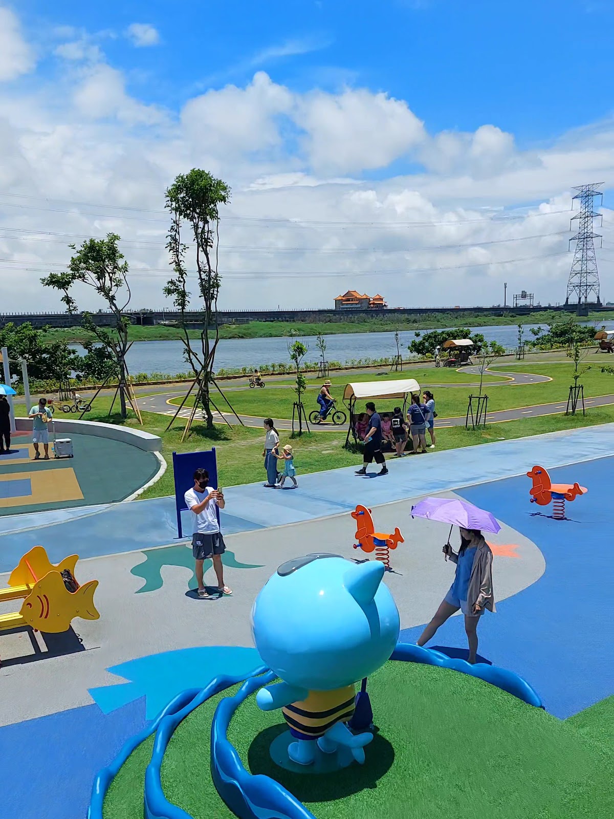 公園內可愛章魚造型裝置藝術,遊客帶著小孩與雨傘散步