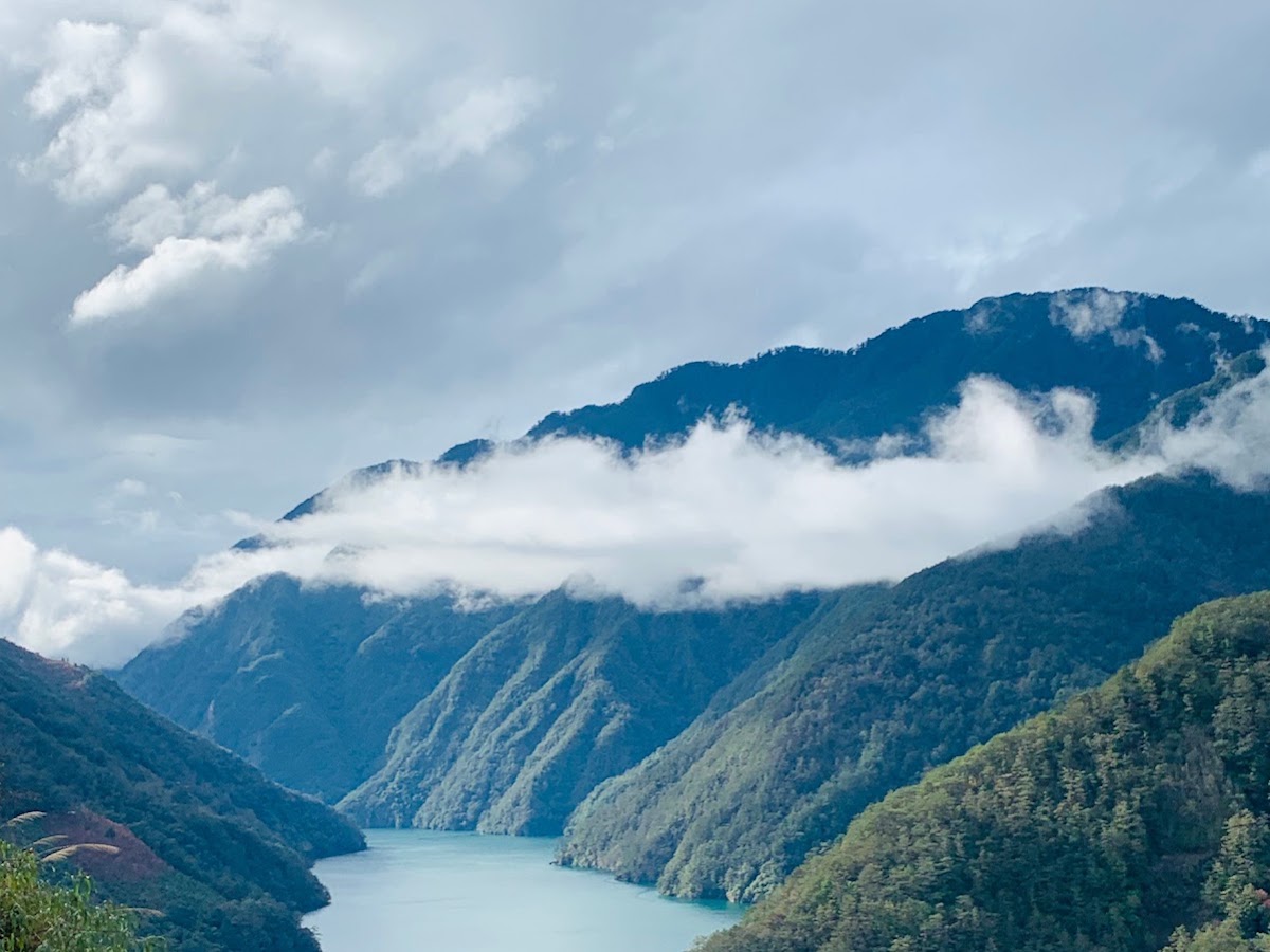 從德基水庫觀壩臺俯瞰翡翠碧水，低雲縈繞山腰峽谷