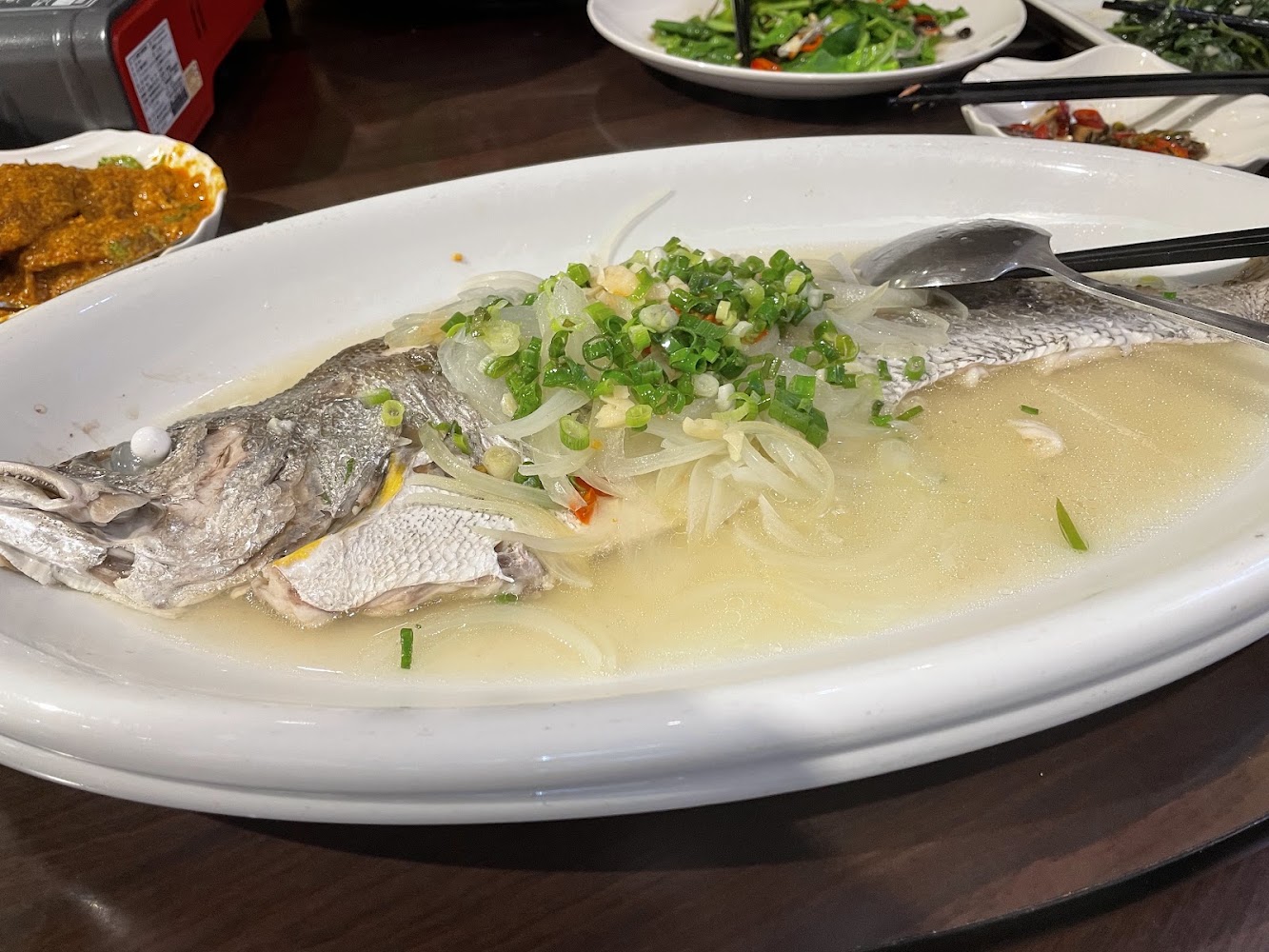 清蒸魚上鋪薑絲蔥花與洋蔥片