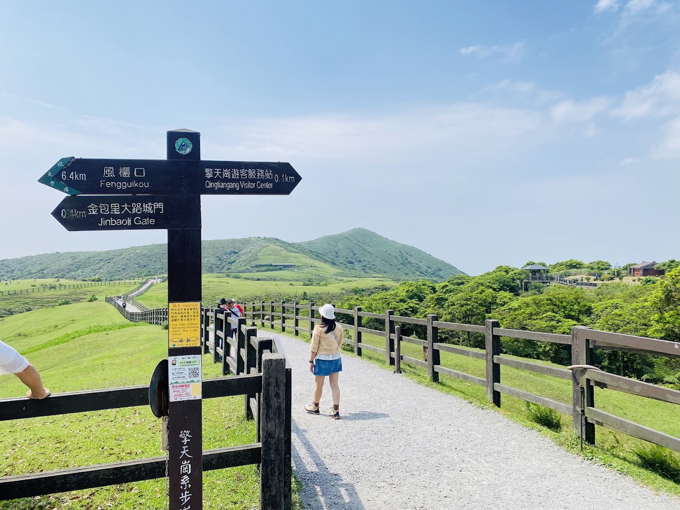 大草原中央有方向指示牌與遠山藍天
