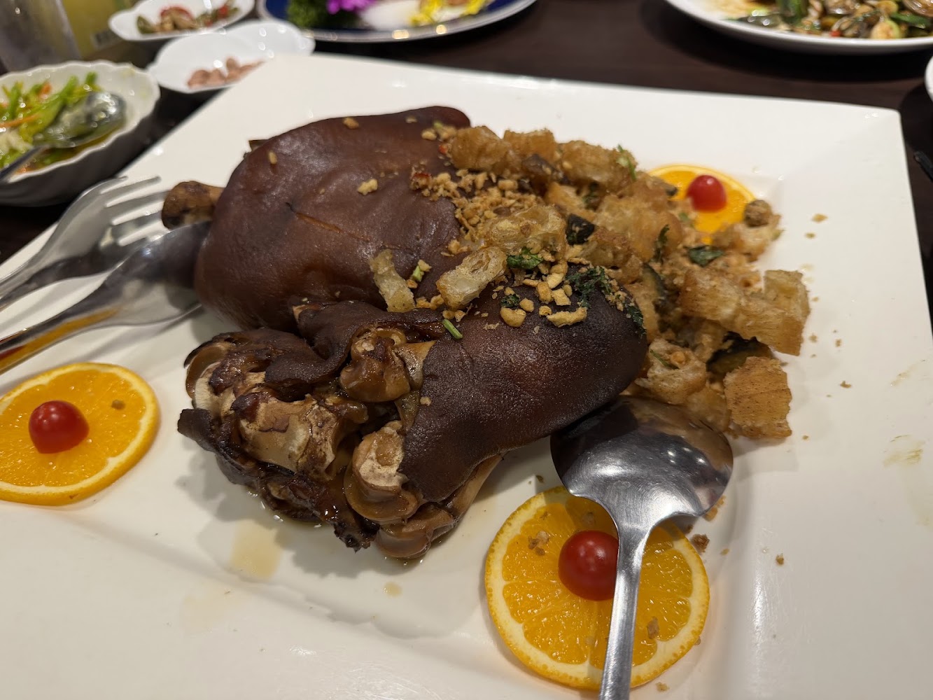 滷豬腳搭配蒜酥與香橙片裝飾